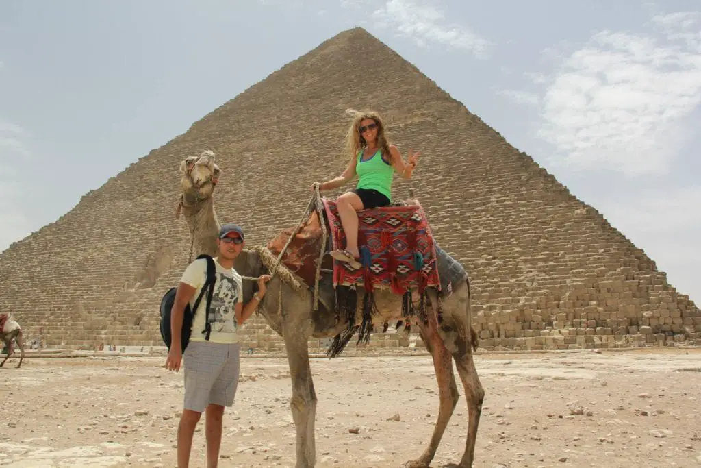 riding a camel in front of the pyramids Egypt 2 week itinerary