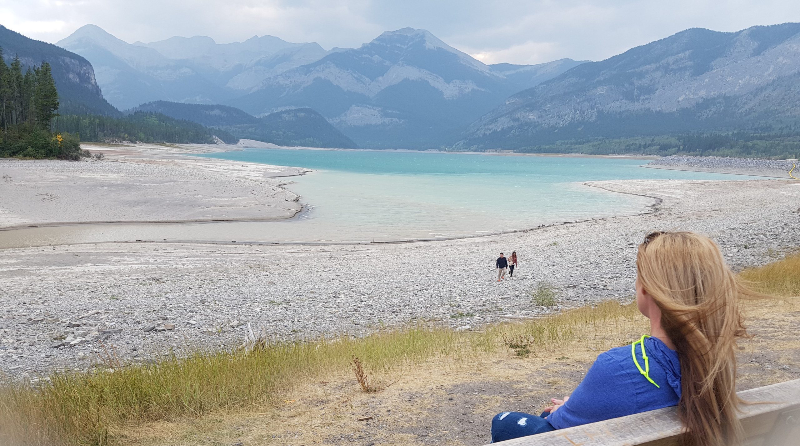 road trip vancouver to banff sitting on a bench seat with blue lake and mountains