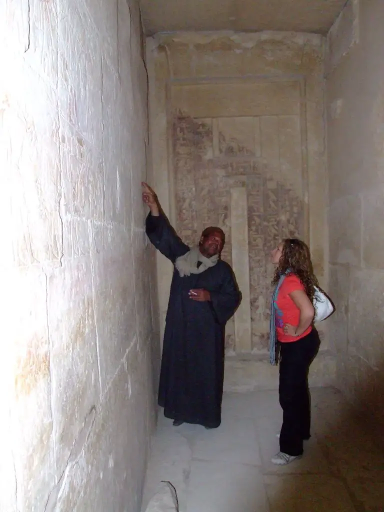 tour guide at Sakkara pyramids explaining wall hieroglyphics -  Egypt on a budget