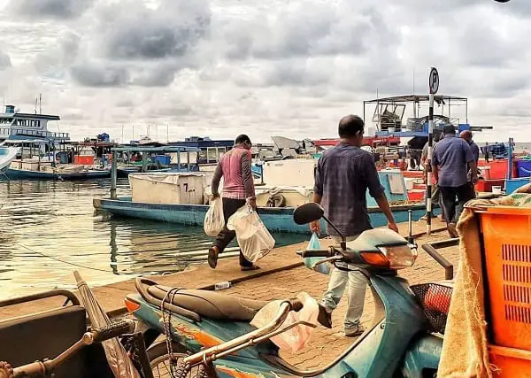 maldives on a budget - on the docks in Male city with men loading cargo on the boat