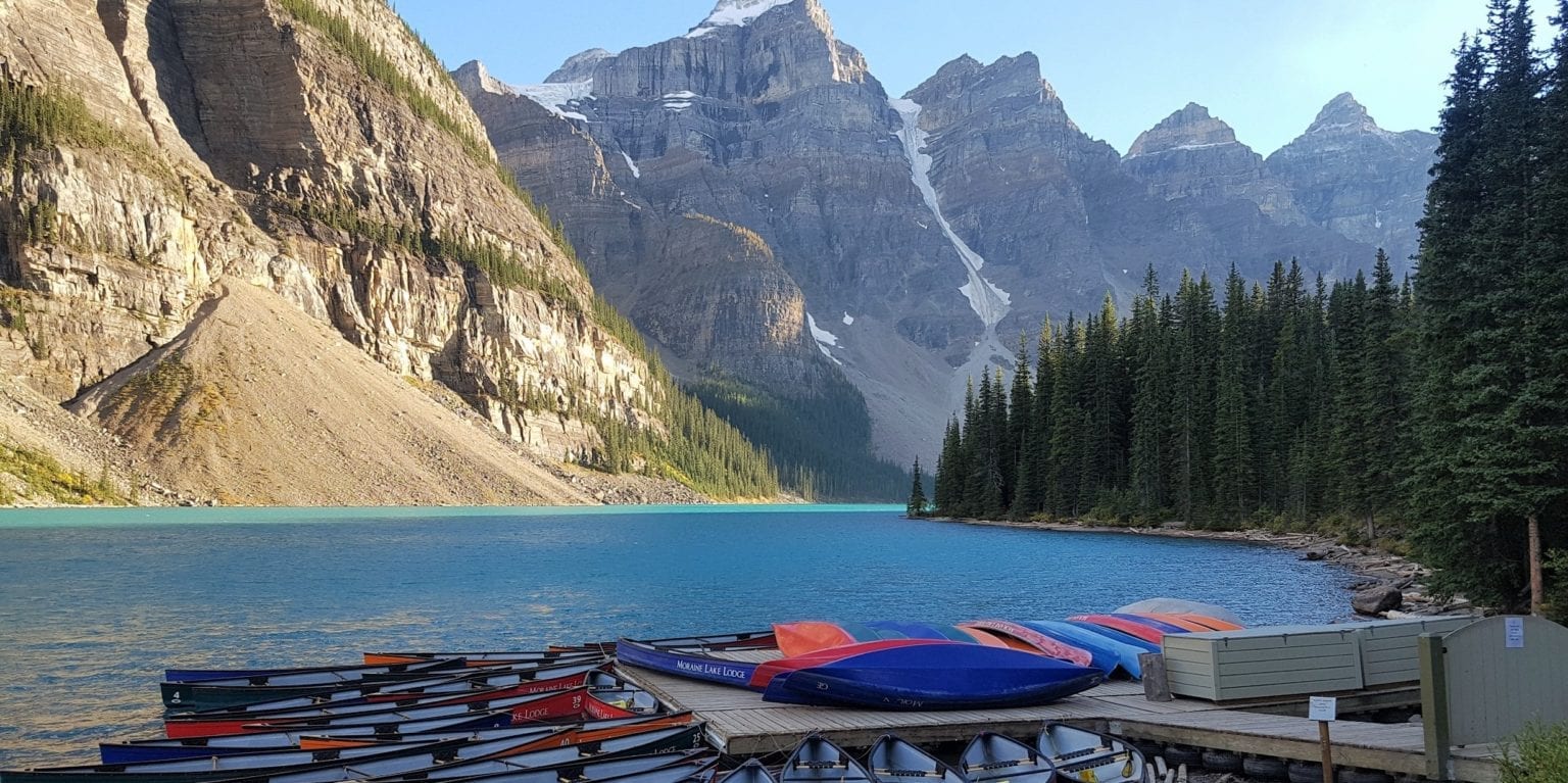 road trip vancouver to banff blue lake mountain in background and canoes in front