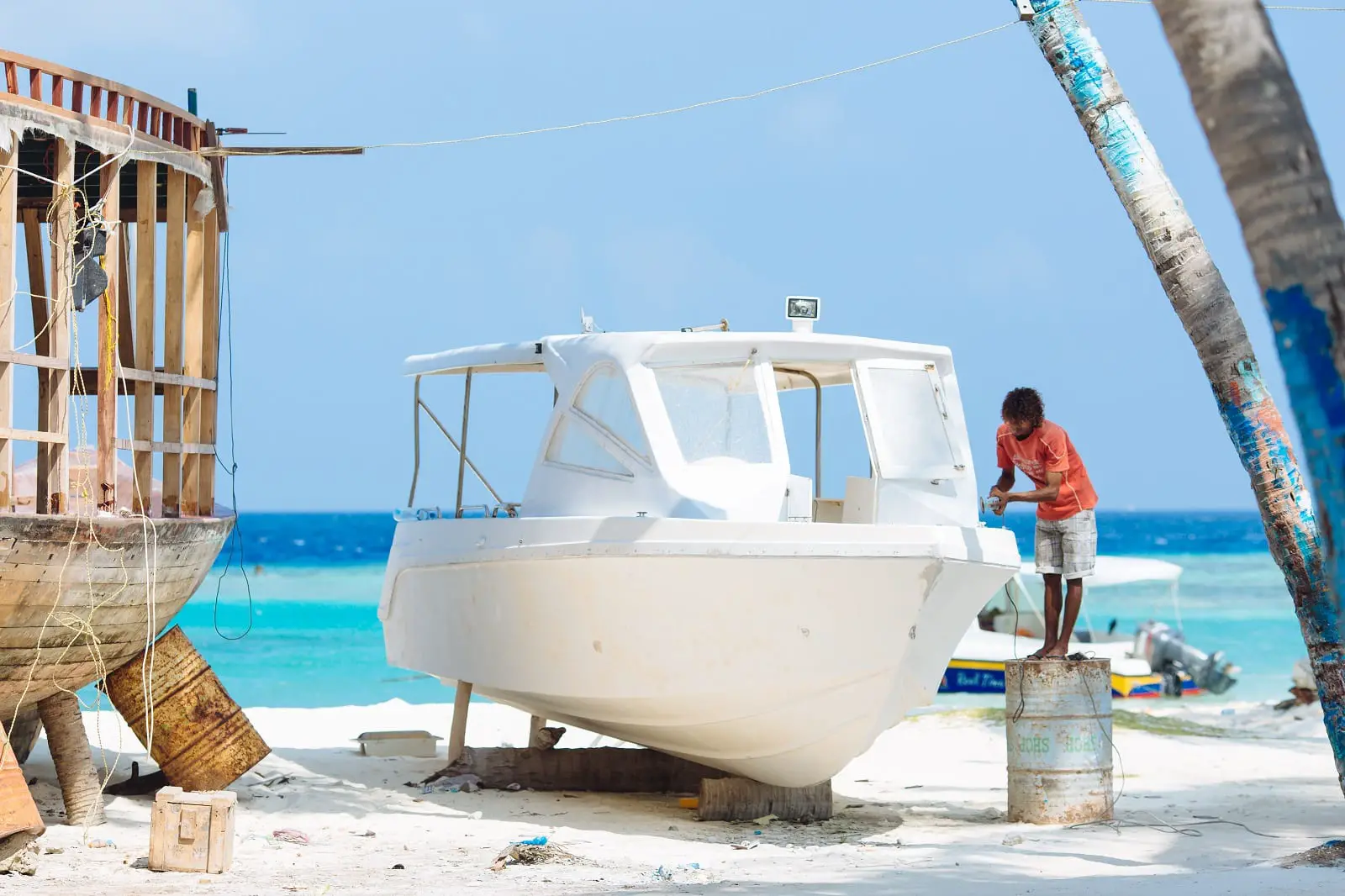man working on boat on the beach