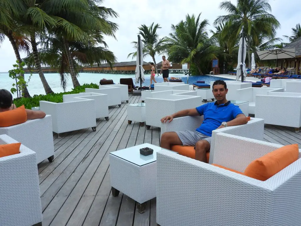 sitting on lounge chairs outdoors with the beach in front on Vilamendhoo island resort and spa maldives