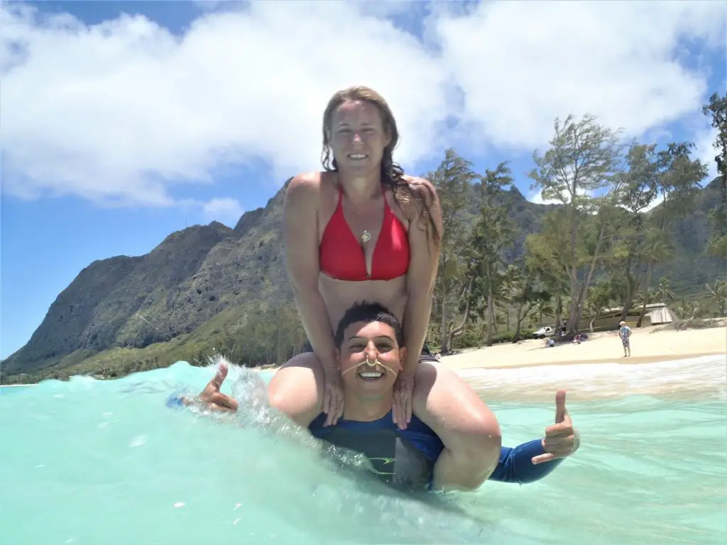 hawaii on a budget - swimming in the water with mountains in background
