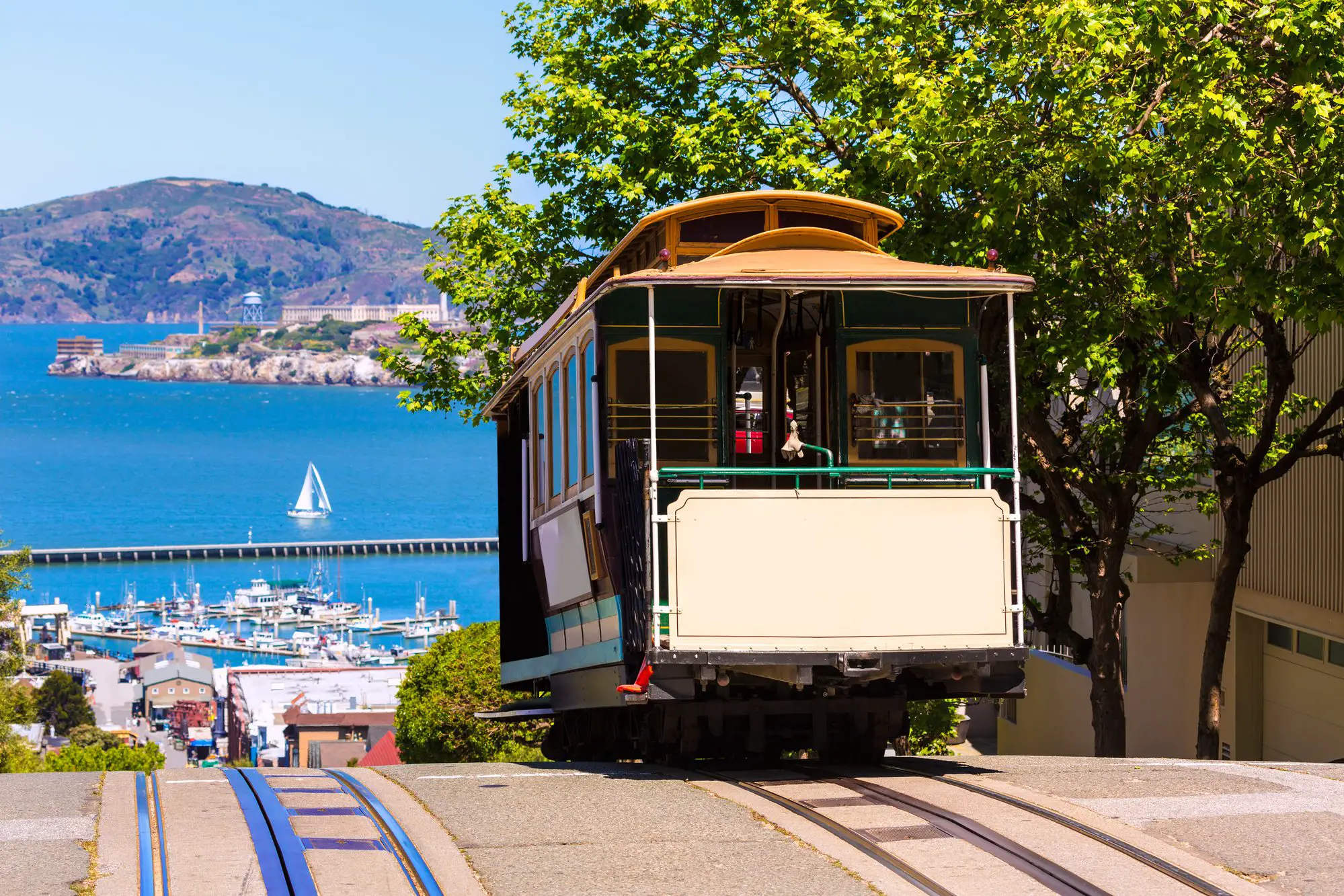San Francisco trolley at top of hill with the bay in the background