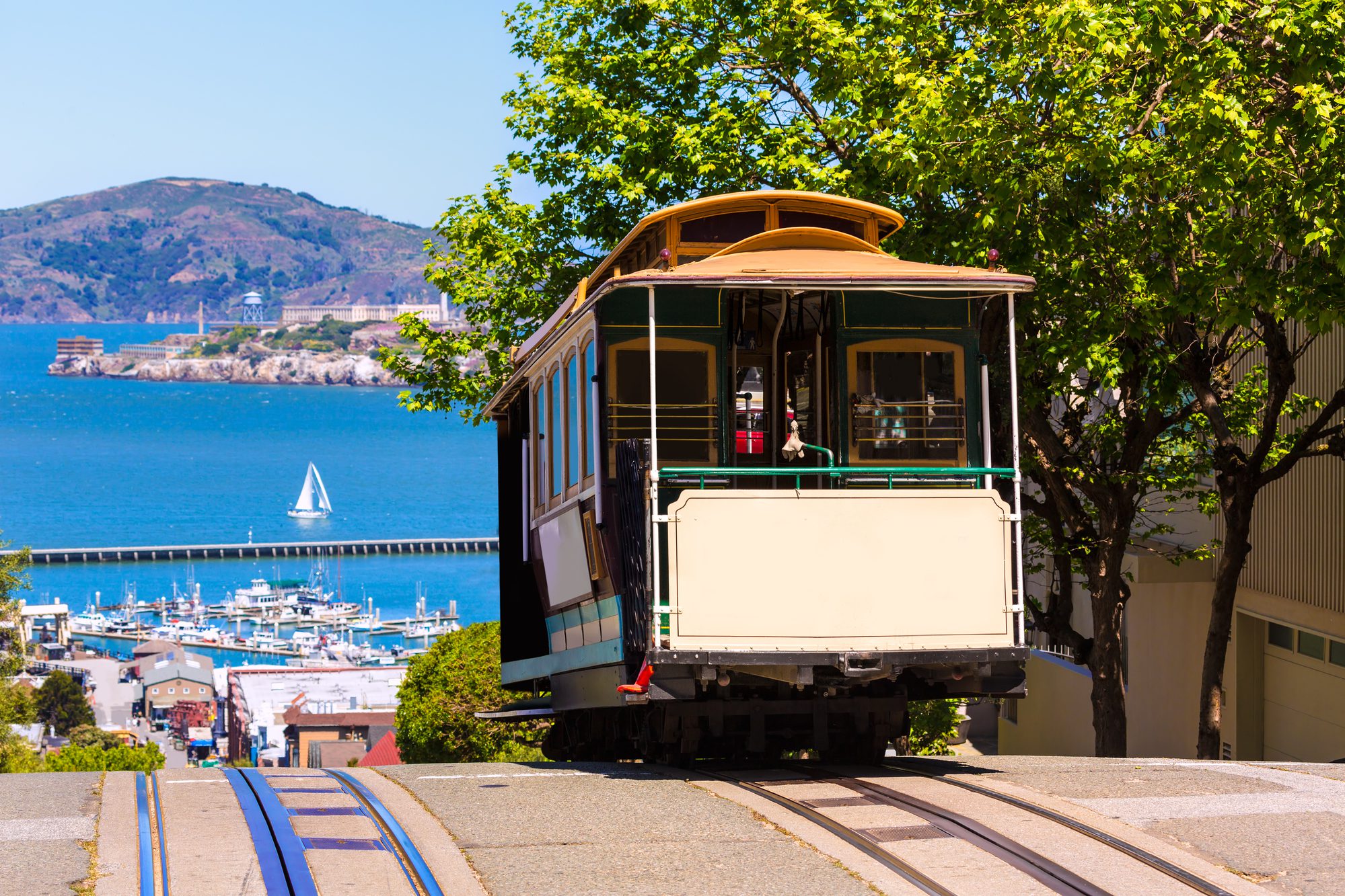 San Francisco trolley at top of hill with the bay in the background