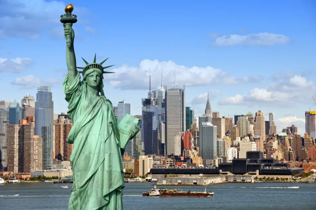 travel USA on a budget = statue of liberty with NYC skyline 