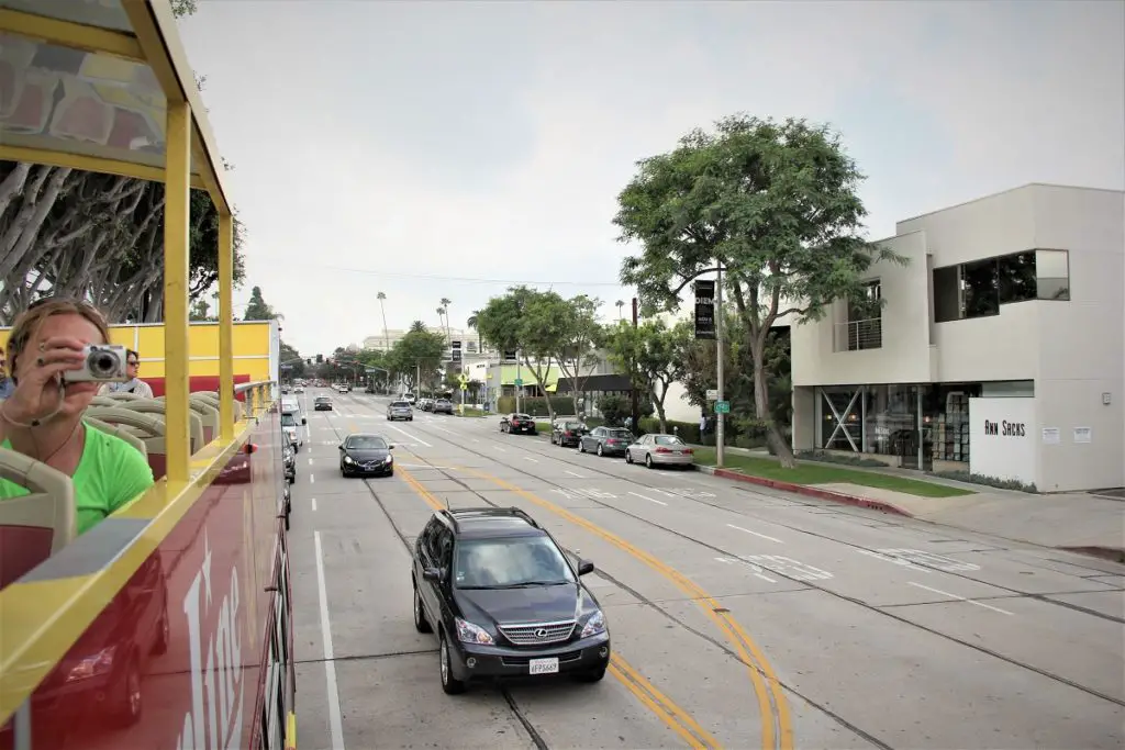 sitting on an open air bus in L.A with camera up and ready -travel USA on a budget