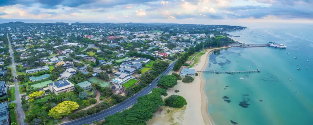 Mornington Peninsula Day Trip - aerial view of Sorrento Pier and Point Neapean road running along side with houses and green trees all round