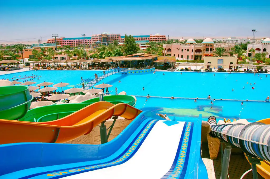 Several water slides as seen from the top of the slides to the water.