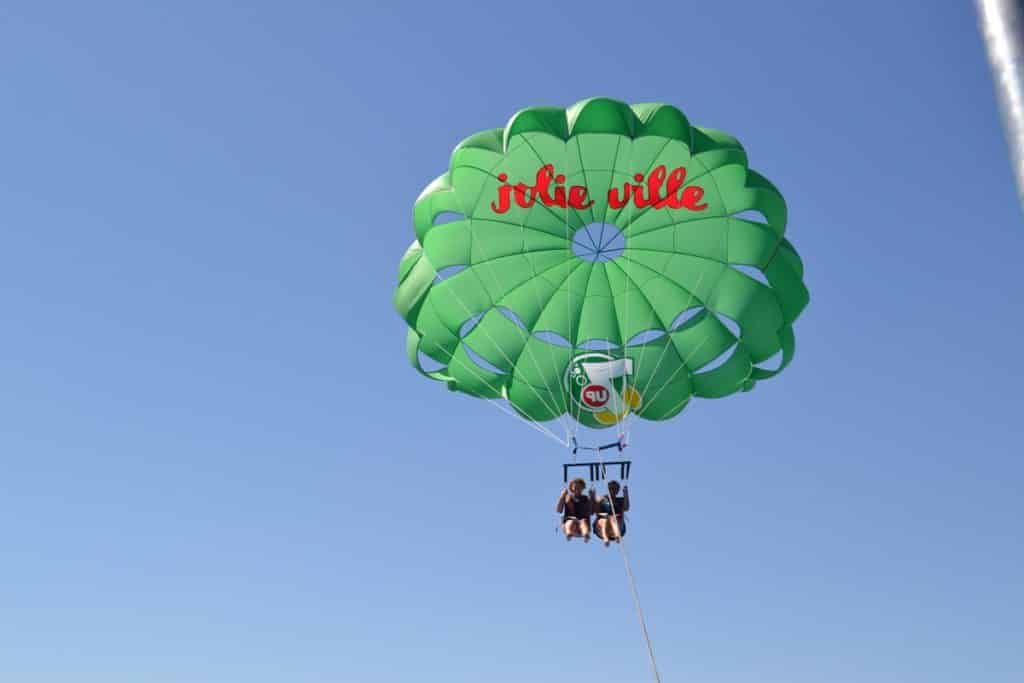 Two people parasailing in the air with a green balloon.Things to do in Sharm El Sheikh