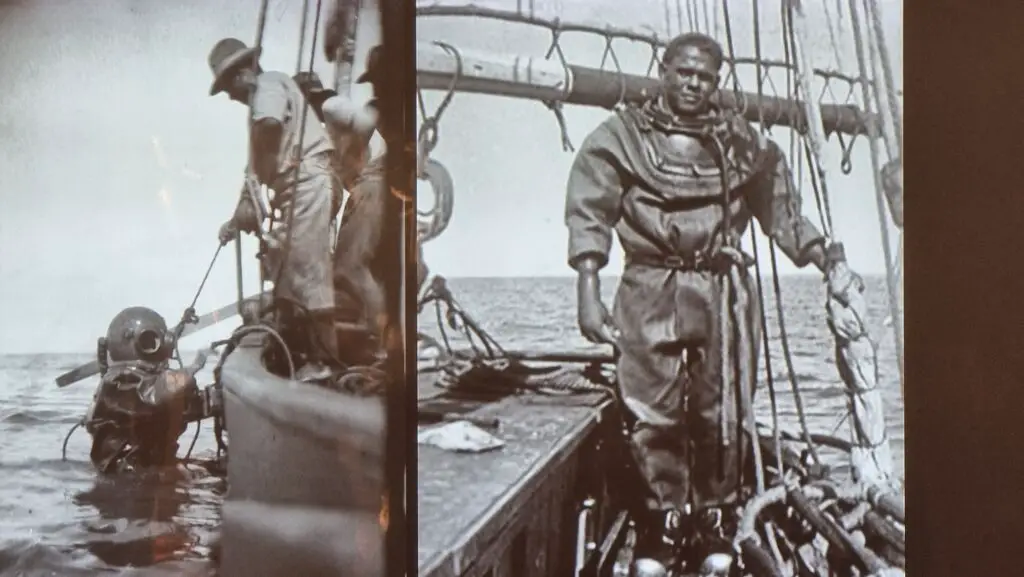 a photo of a man wearing heavy dive equipment ona boat 