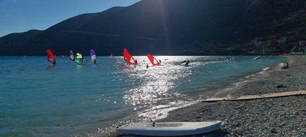 wind surfers on the water in the glistening light on our mainland Greece itinerary