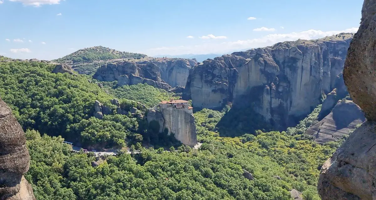 Looking out toward the monasteries of Meteora on our mainland Greece itinerary. With high cliffs and dense trees in the valley. 