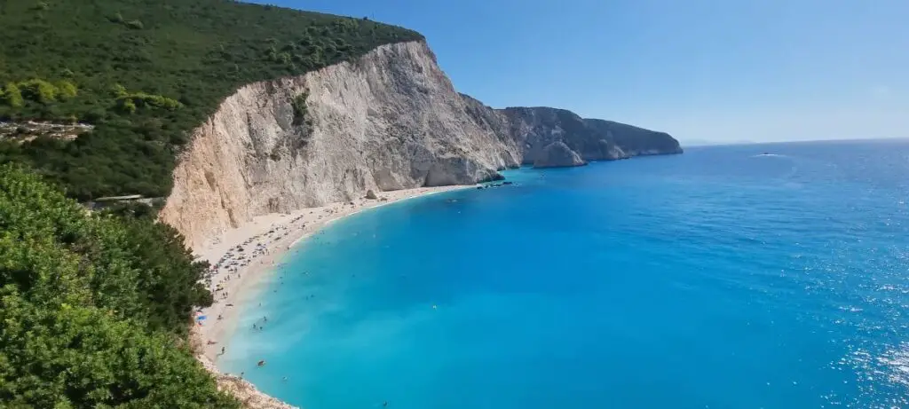 a side view of Porto Katsiki beach with towering cliff and azure waters